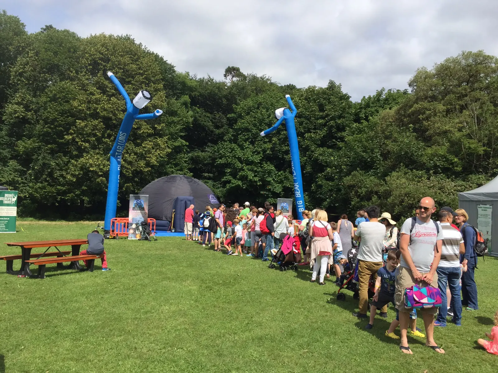 Families queueing for a planetarium show at a festival